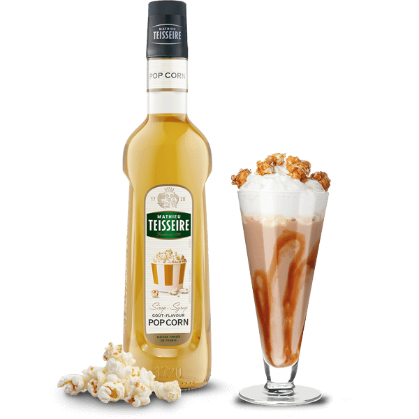 Bottle of Teisseire Pop Corn syrup with a glass of syrup and popcorn on a white background