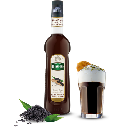 Bottle of Teisseire syrup with a shot glass filled with the syrup on a white background