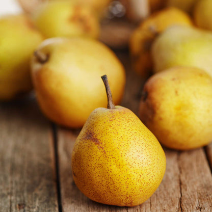 Pear on a wooden surface with other pears in the background