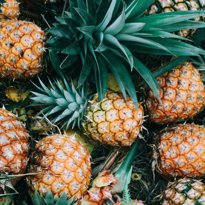 Close-up of a bunch of pineapples with green leaves.