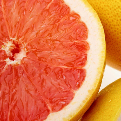 Close-up of a sliced grapefruit with pinkish-red flesh and white pith.