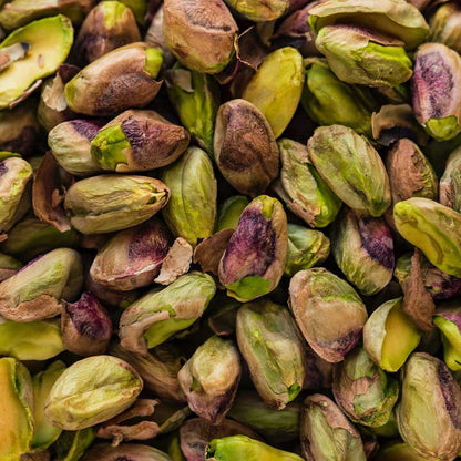 Close-up of pistachios with green and brown shells.