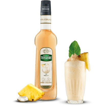 Bottle of Teisseire Pina Colada syrup with a cocktail and pineapple garnish on a black background