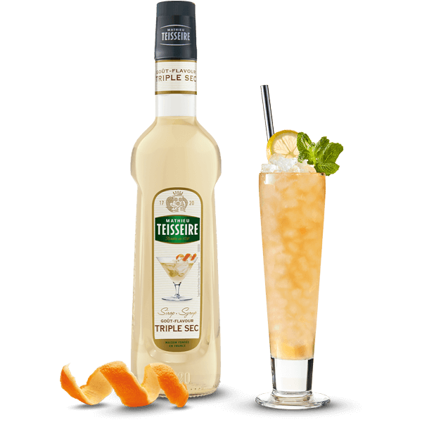 Bottle of Teisseire triple sec with a cocktail garnished with an orange peel and mint leaf on a white background