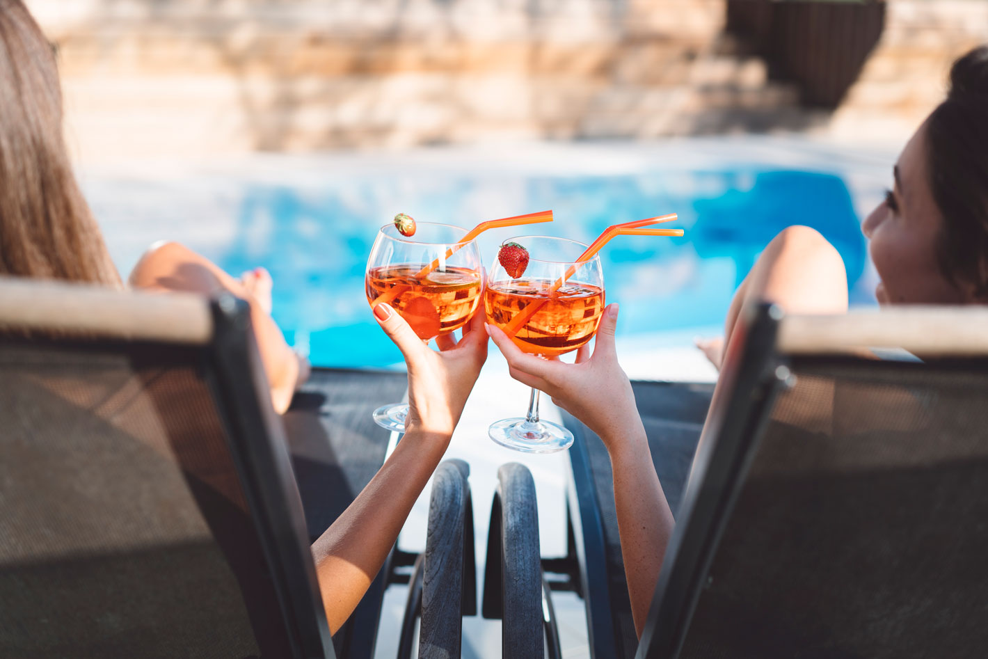 toasting of drinks by a pool